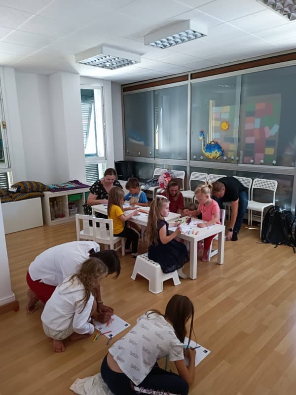 Group of kids coloring dibulo templates in a kindergarten