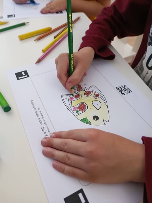 Kid coloring a dibulo coloring template of a fish